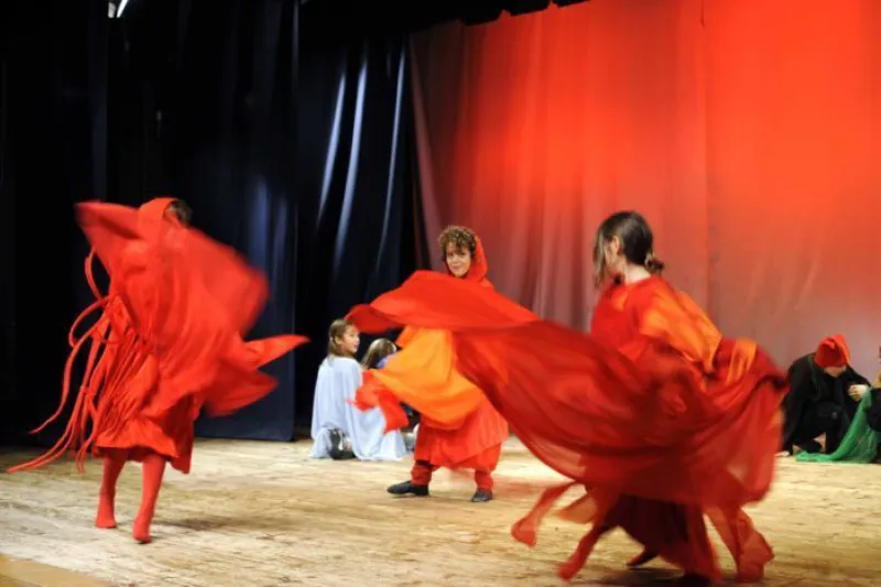 Ragazze in costumi rossi danzano sul palco durante uno spettacolo
