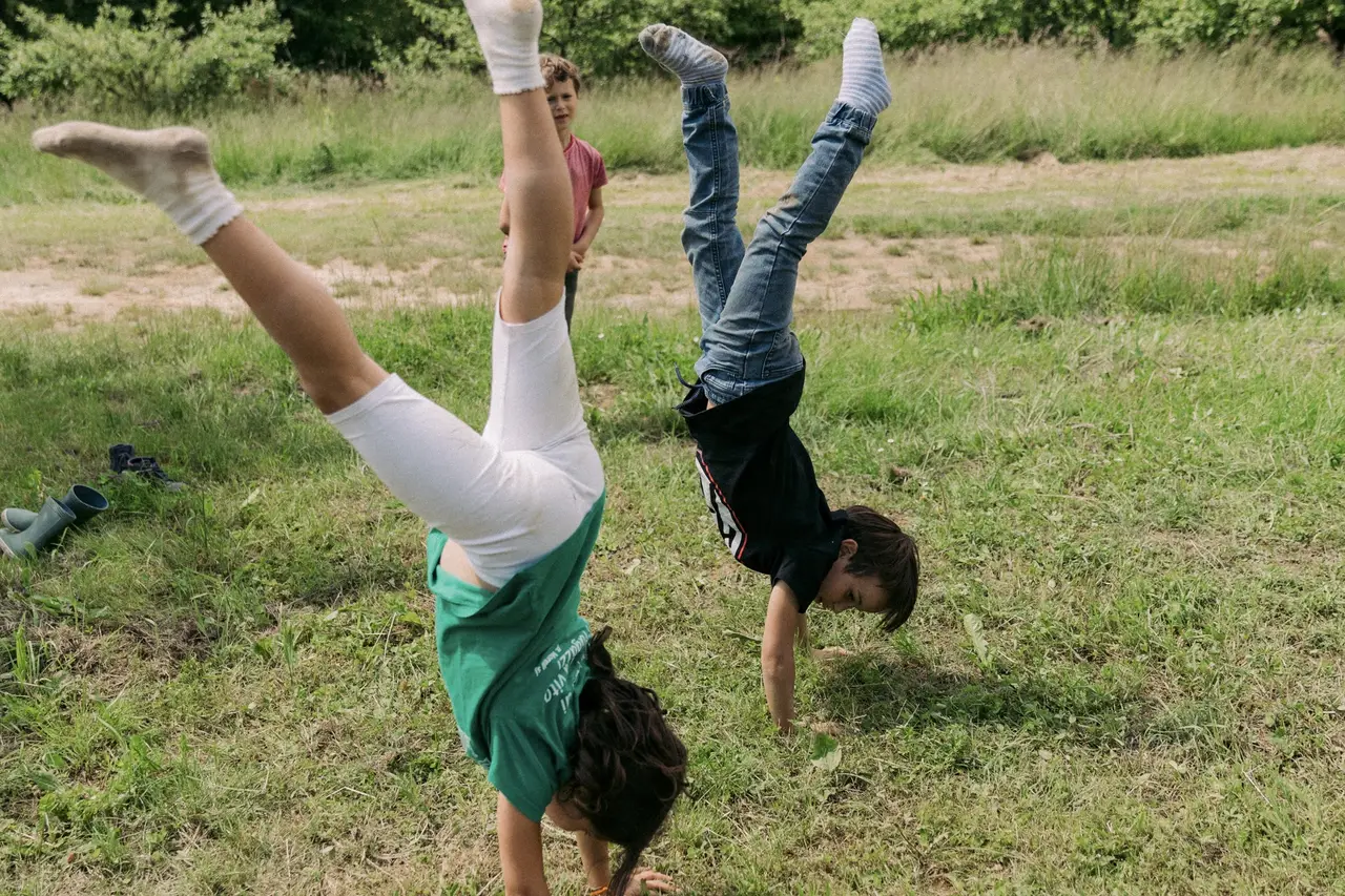 Due bambini fanno la ruota su un prato verde