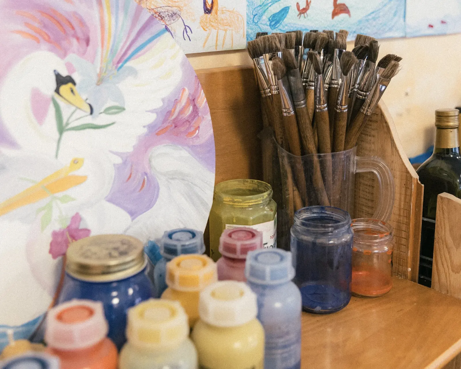 Pennelli e barattoli di colore davanti a una pittura