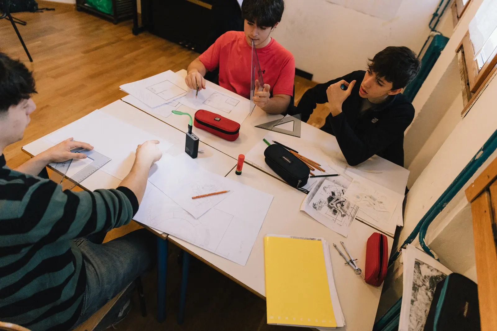 Studenti disegnano progetti di architettura intorno a un tavolo