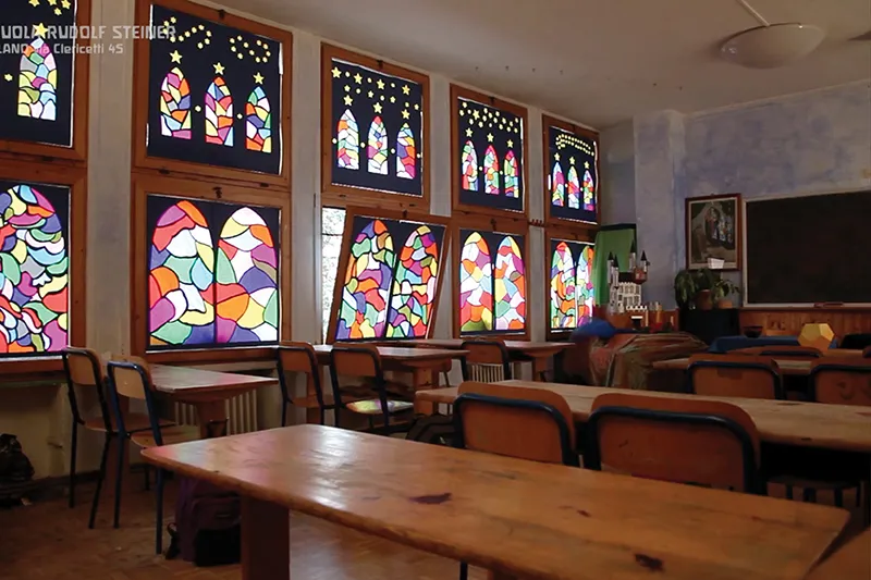 Un'aula vuota con le vetrate colorate dipinte dagli alunni