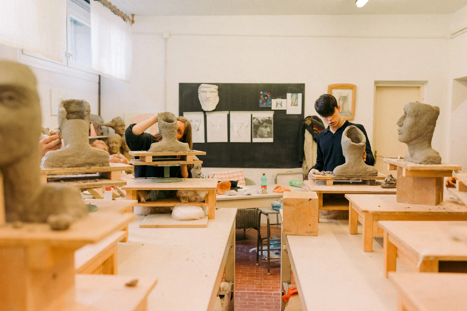 Studenti modellano busti sui tavoli del laboratorio