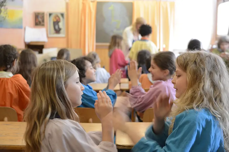 Bambini giocano a battimani insieme in classe